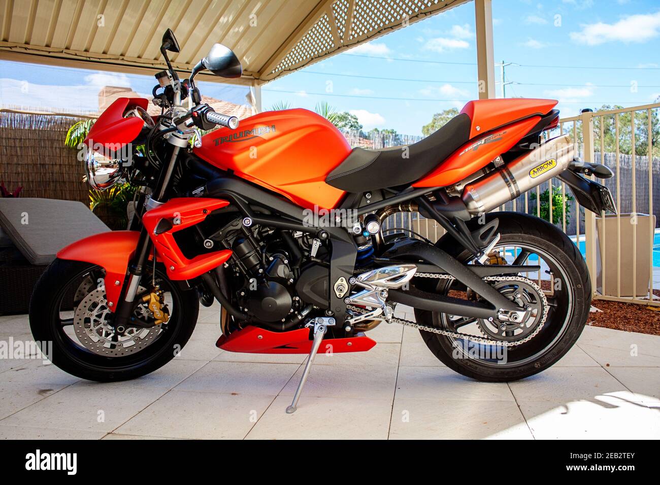 2010 Triumph Street Triple R moto arancione, parcheggiata su pavimentazione  sotto un patio Foto stock - Alamy