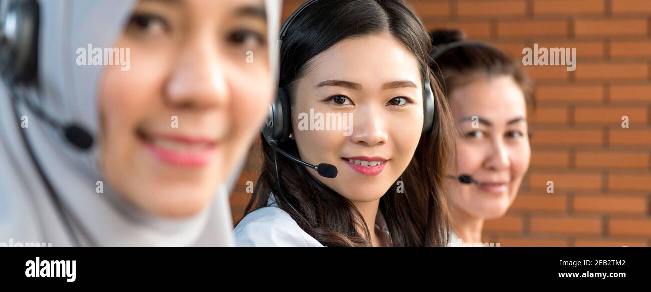 Diverse donne asiatiche che lavorano negli uffici del call center come operatori del servizio clienti, banner panoramico Foto Stock