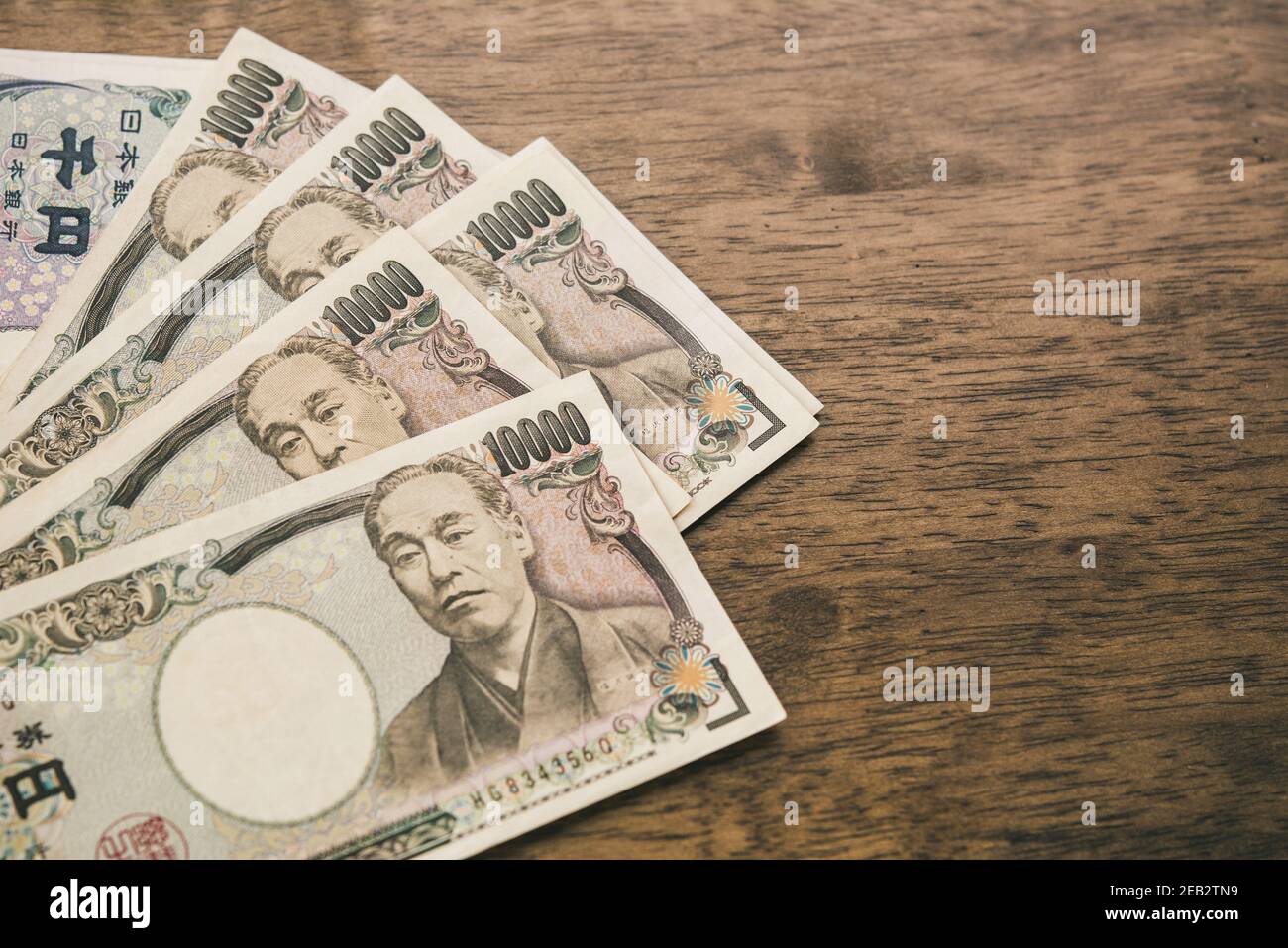 Diecimila banconote giapponesi Yen su tavola di legno con copia spazio per il concetto finanziario Foto Stock