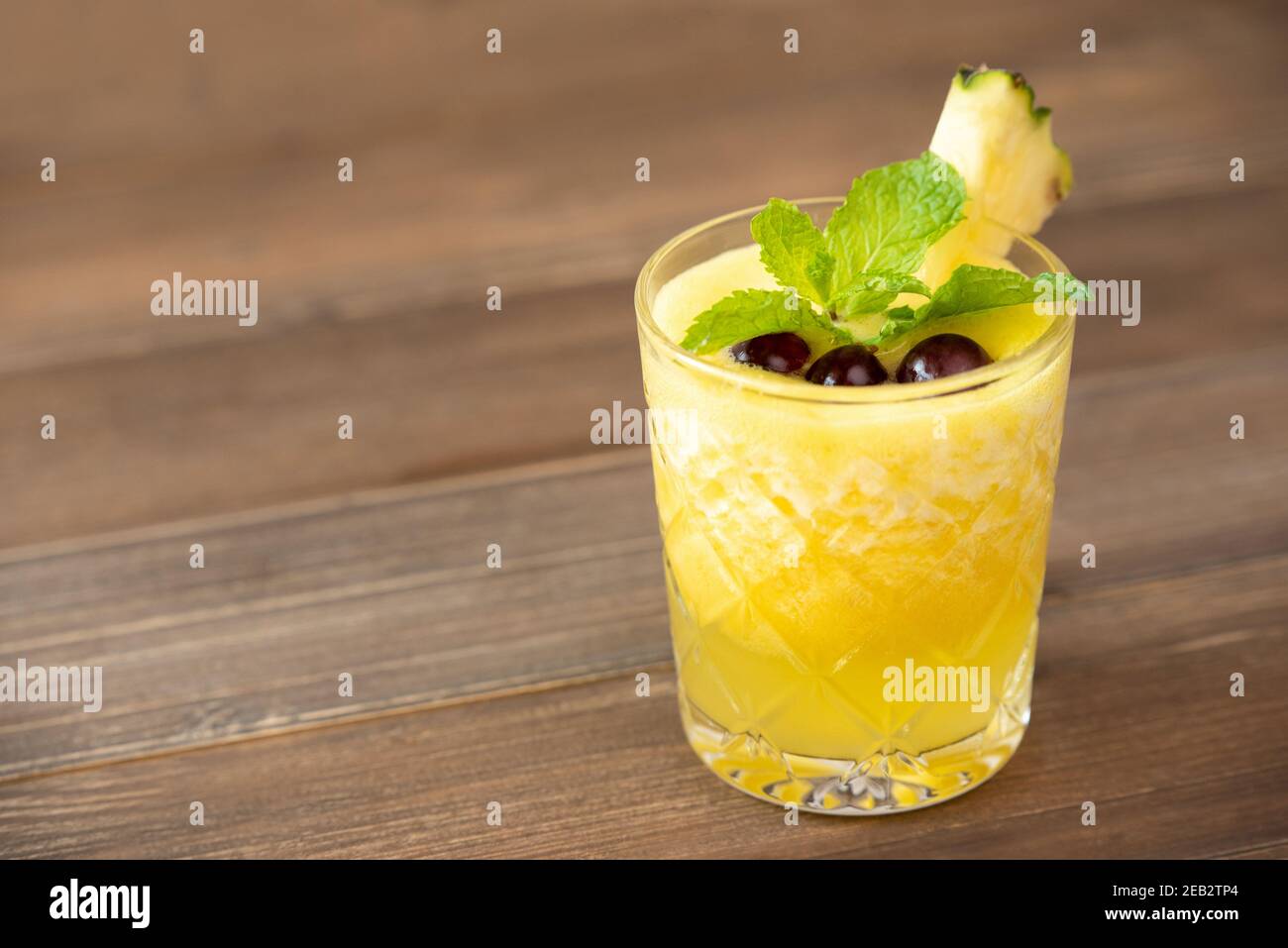 Rinfrescante sano frullato di frutta di ananas bevanda su tavola di legno Foto Stock