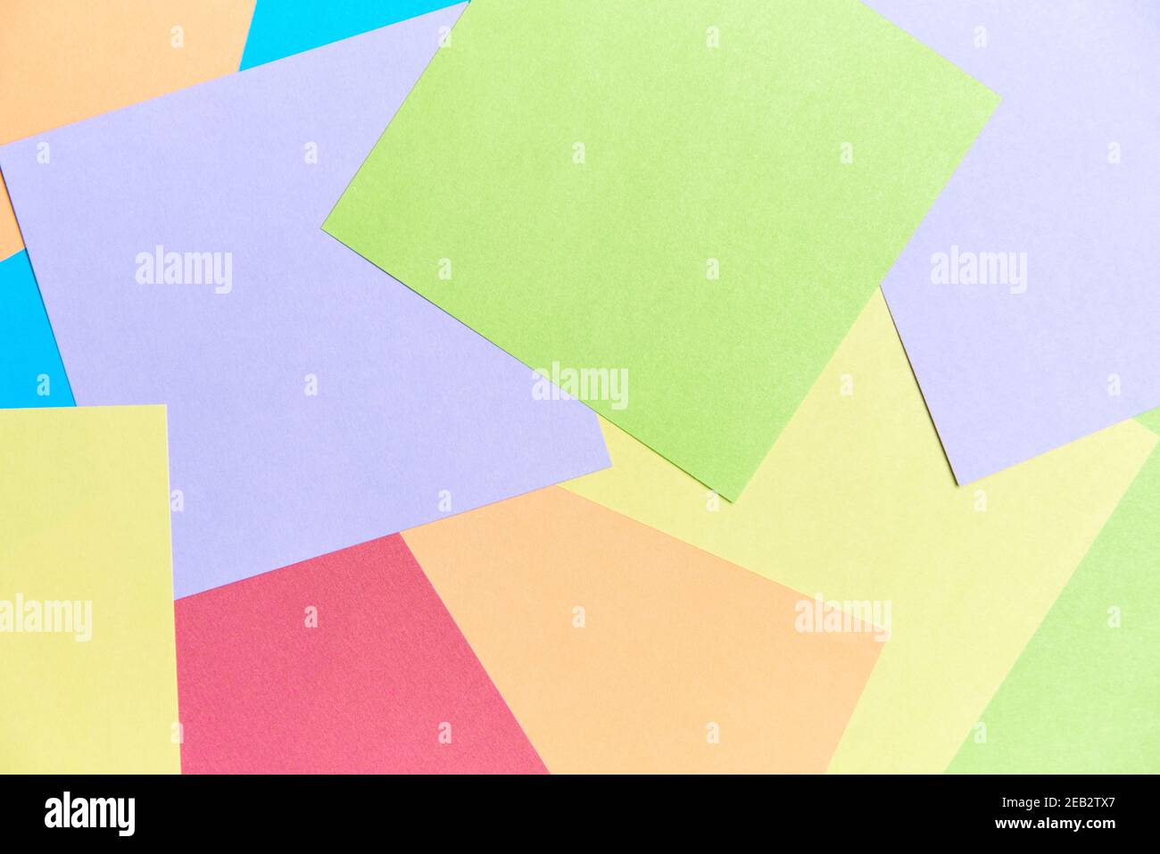 Sfondo colorato: Fogli quadrati di carta di diversi colori che riempiono la cornice. Forniture per ufficio o scuole, per prendere appunti o per fare origami Foto Stock