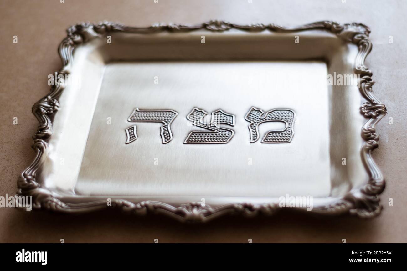 Un vassoio d'argento con la parola matzah scritta in ebraico, progettato per matzah, che è un pane speciale per la Pasqua Foto Stock