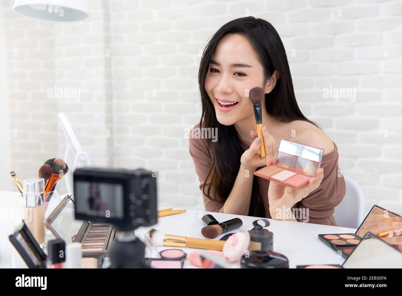 Giovane bella donna asiatica bellezza vlogger o blogger registrazione cosmetica crea un tutorial video da condividere sui social media Foto Stock