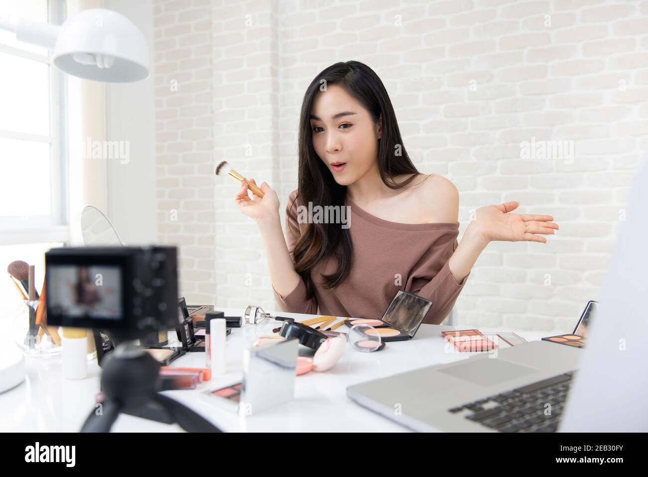 Bella donna asiatica professionale cosmetica e bellezza vlogger registrazione trucco rivedi per condividere sui social media Foto Stock