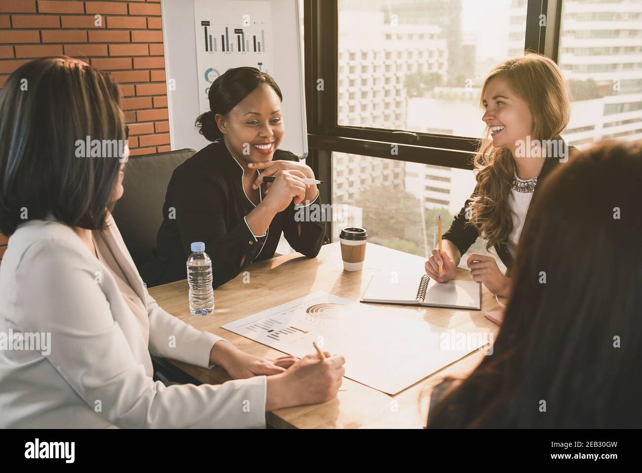 Felice leader di diverse imprese nella sala riunioni Foto Stock