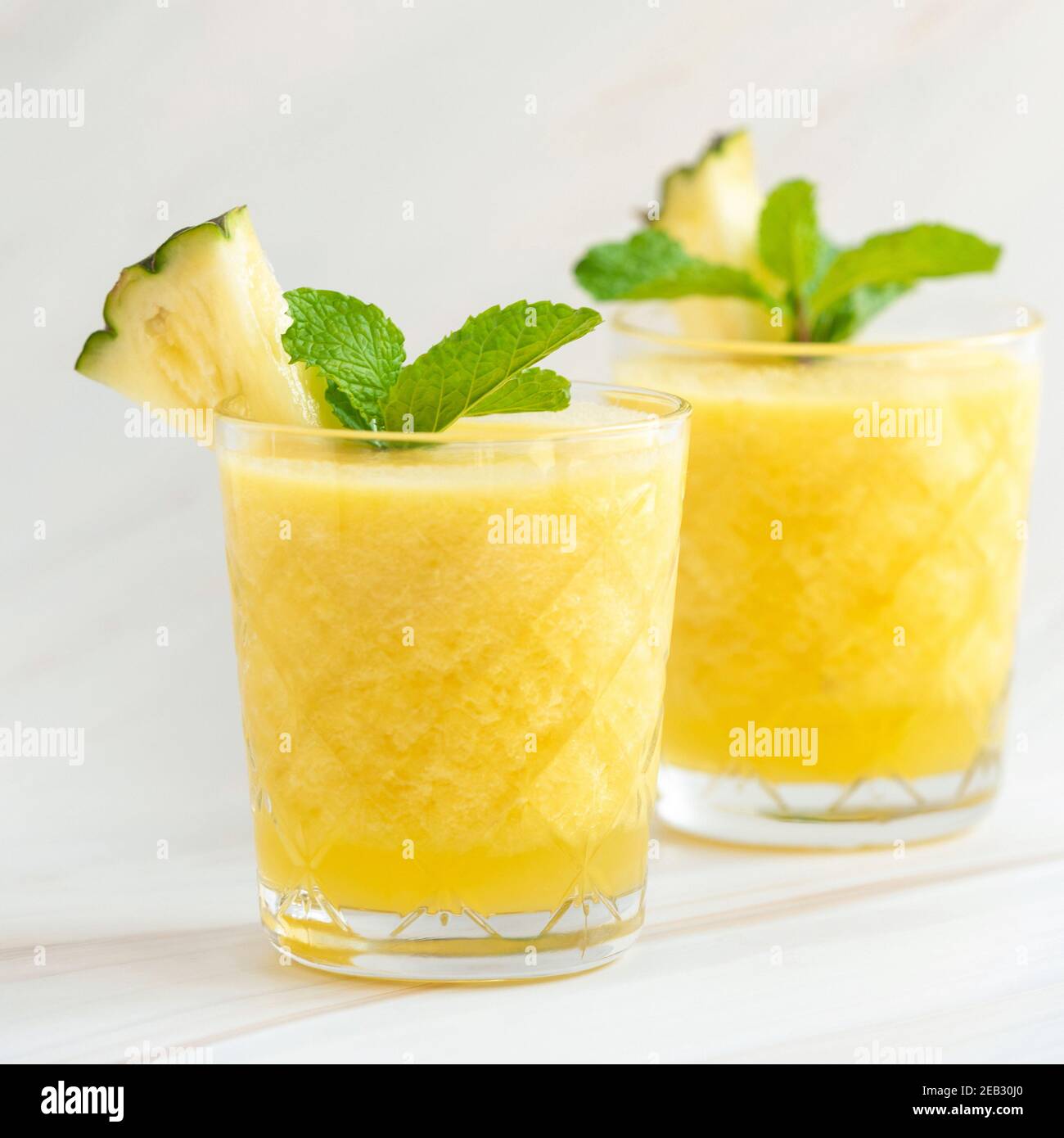 Bevande rinfrescanti sane frullato di frutta di ananas su bancone di marmo bianco Foto Stock