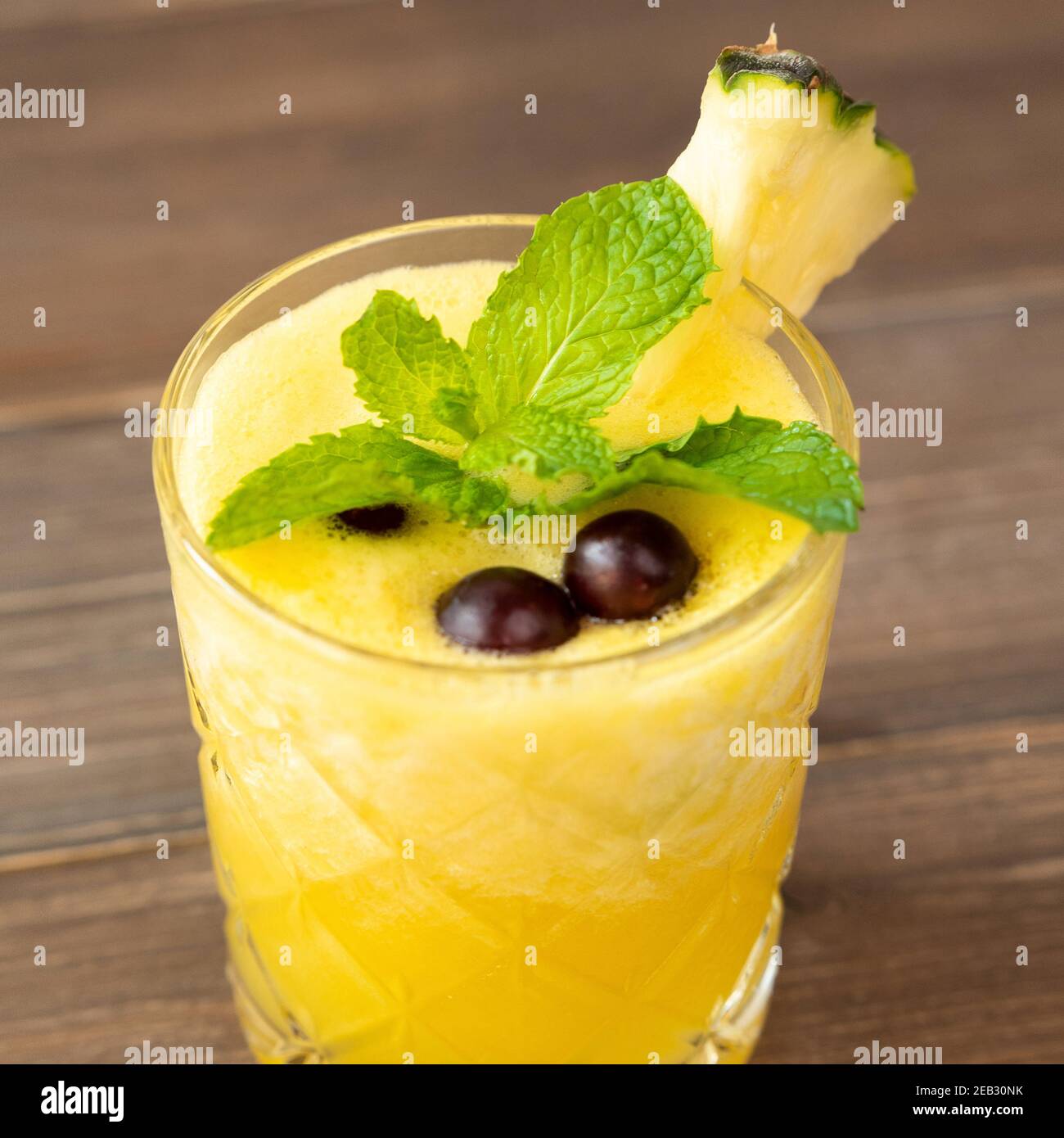 Primo piano di una rinfrescante bevanda estiva all'ananas tropicale su sfondo tavolo di legno Foto Stock