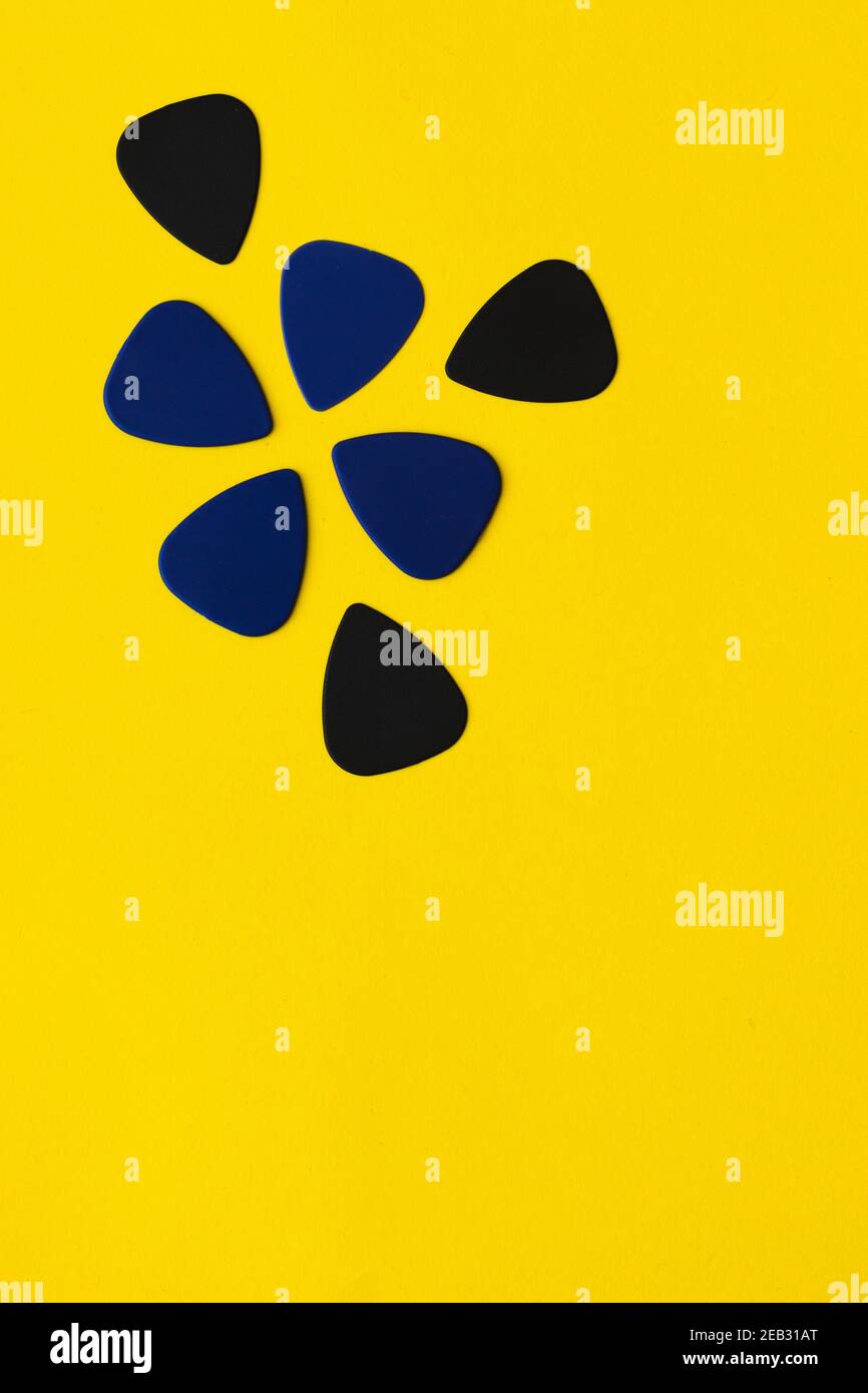 I picks della chitarra sono posizionati su uno sfondo giallo Foto Stock