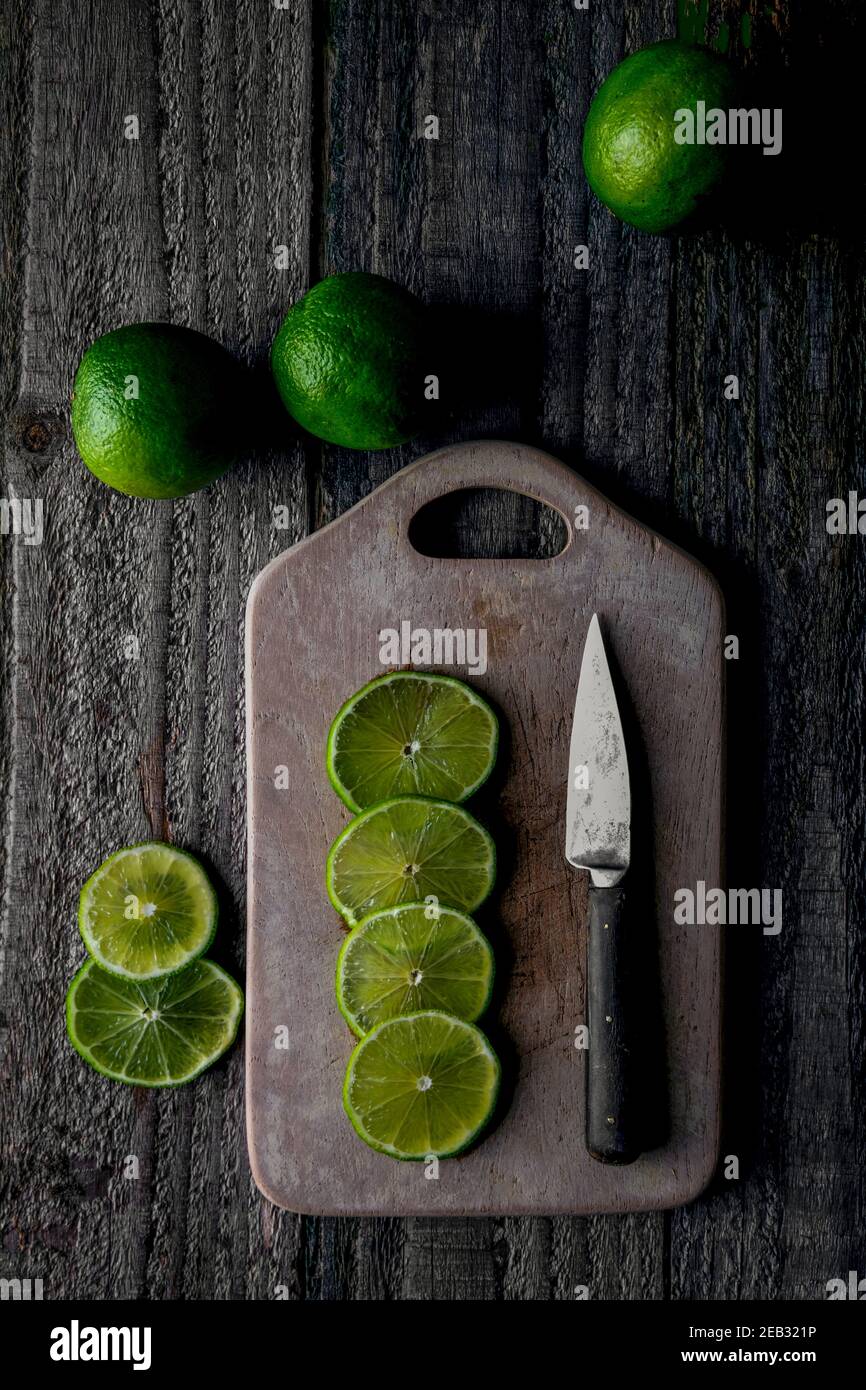 Fette di lime tagliate sul tagliere Foto Stock