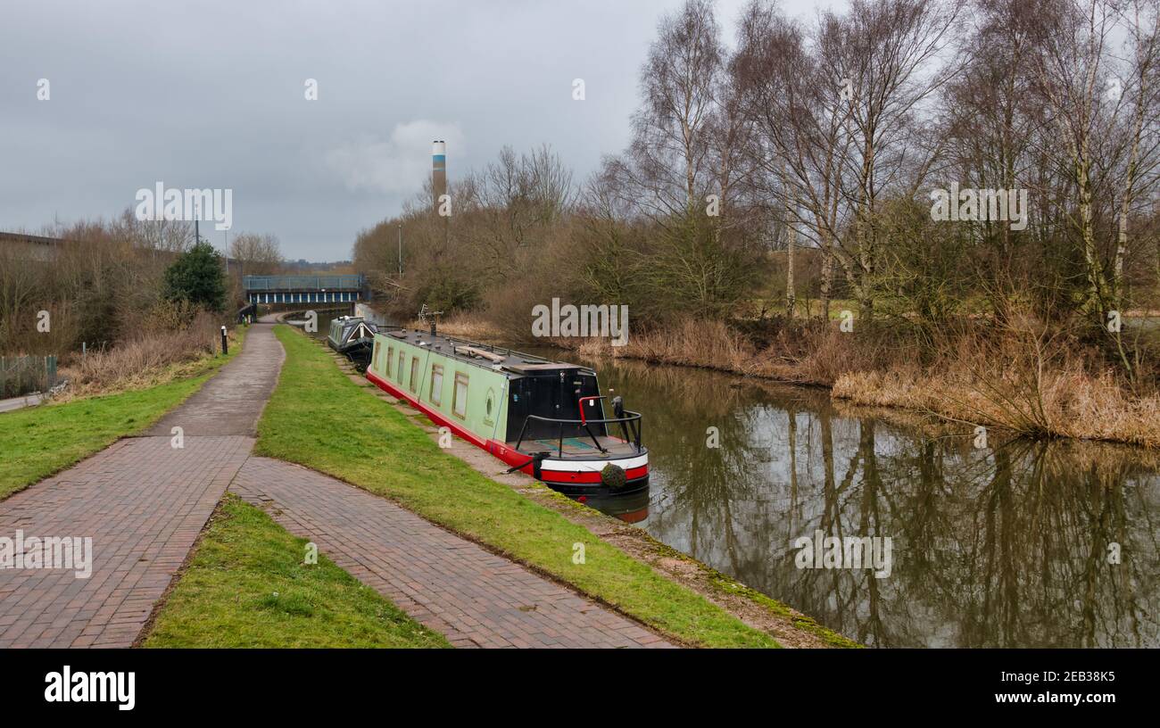 Si affaccia su un canale con due barche ormeggiate sulle persone sul percorso di traino Foto Stock