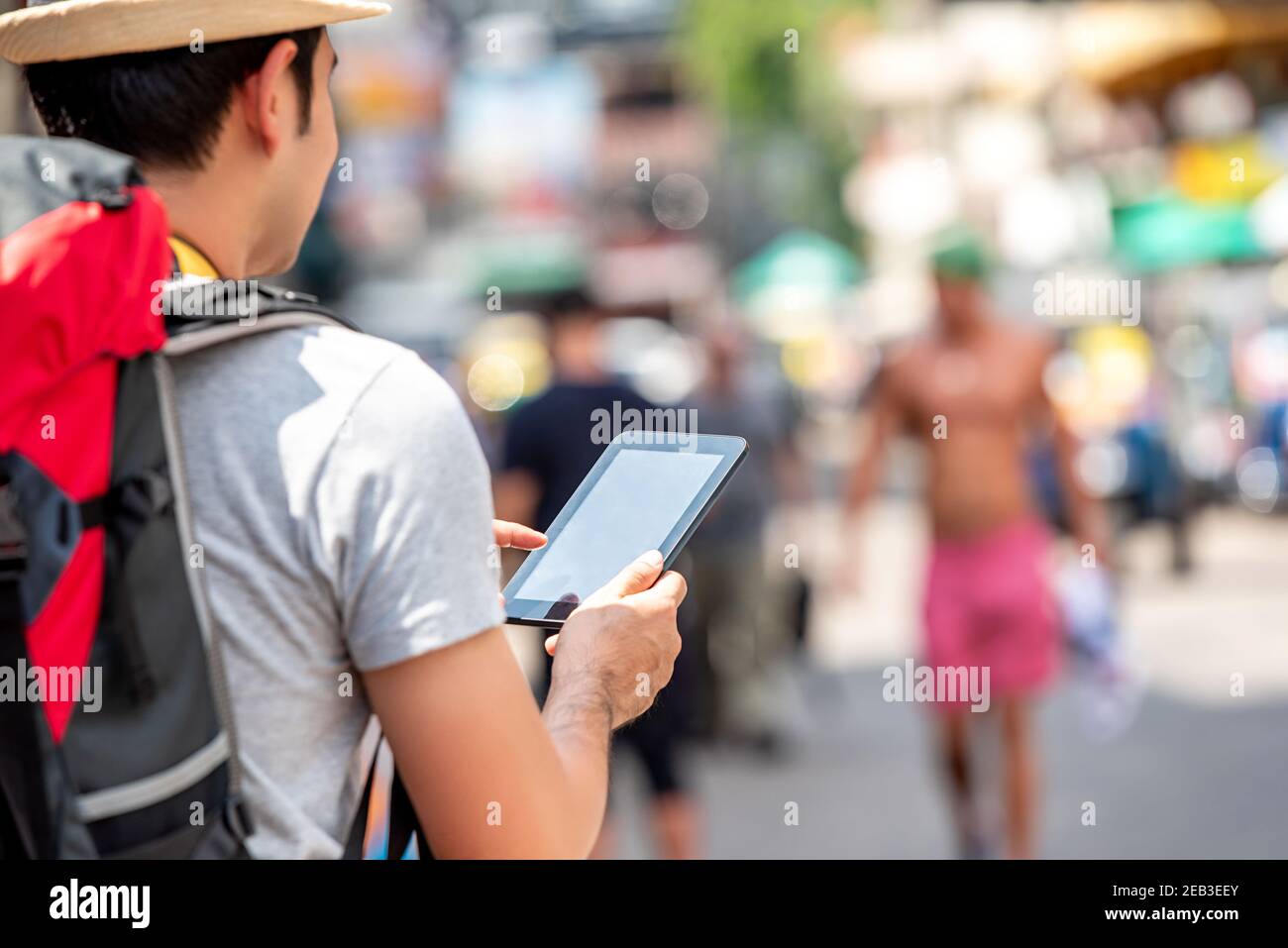 Saccopelatore turistico maschile utilizzando computer tablet alla ricerca di posizione mentre Viaggiare in vacanza a Khao San Road Bangkok Thailandia Foto Stock