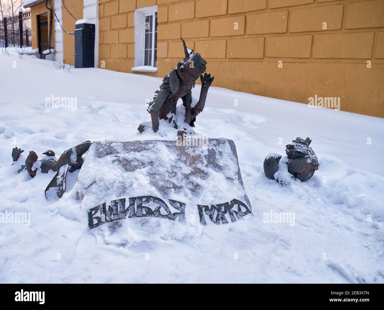 La vista della scultura del marchio composizione di due cani delle pulci e di un gatto sdraiati per riposare su una pietra con l'iscrizione "collina lousy" sotto la neve. Nizhny T Foto Stock