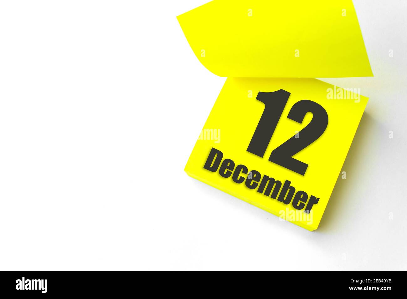 12 dicembre. Giorno 12 del mese, data del calendario. Primo piano promemoria carta giallo vuoto Nota adesiva su sfondo bianco. Mese invernale, giorno dell'anno con Foto Stock