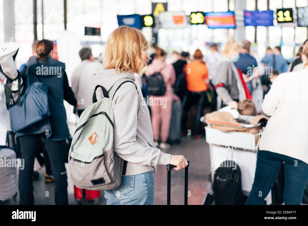 Persone non riconoscibili, vista dal retro, coda in aeroporto per il check-in. Foto Stock