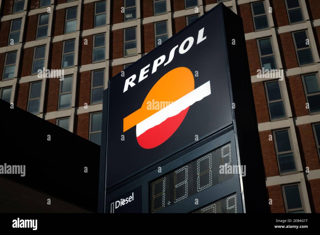 Logo Repsol in una stazione di servizio all'interno della città contro una facciata dell'edificio. Repsol è un'importante azienda energetica spagnola con sede a Madrid Foto Stock