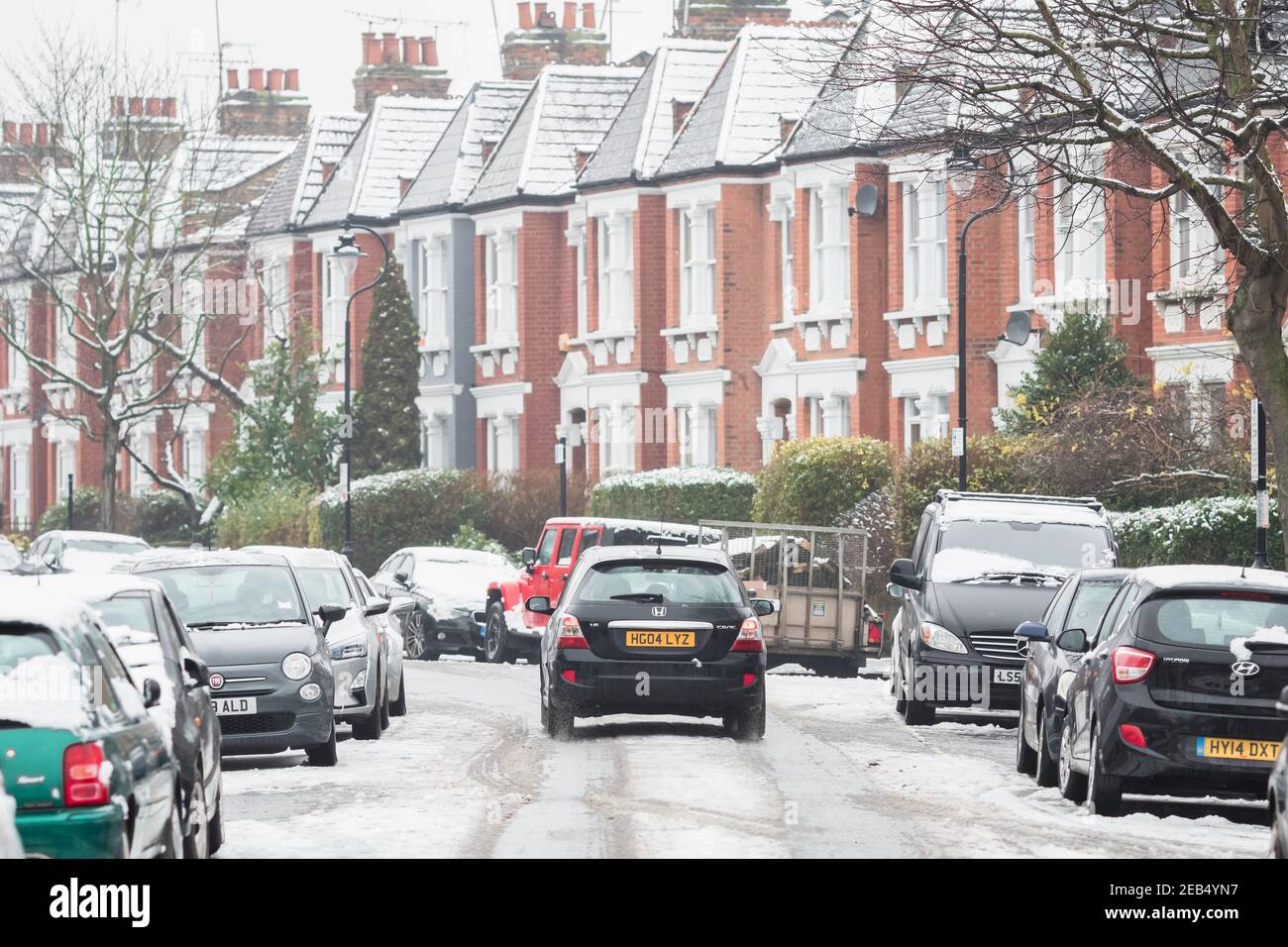 Londra, Regno Unito - 9 febbraio 2021 - un'auto che guida su una strada coperta di neve a Crouch End, condizioni di guida avverse Foto Stock