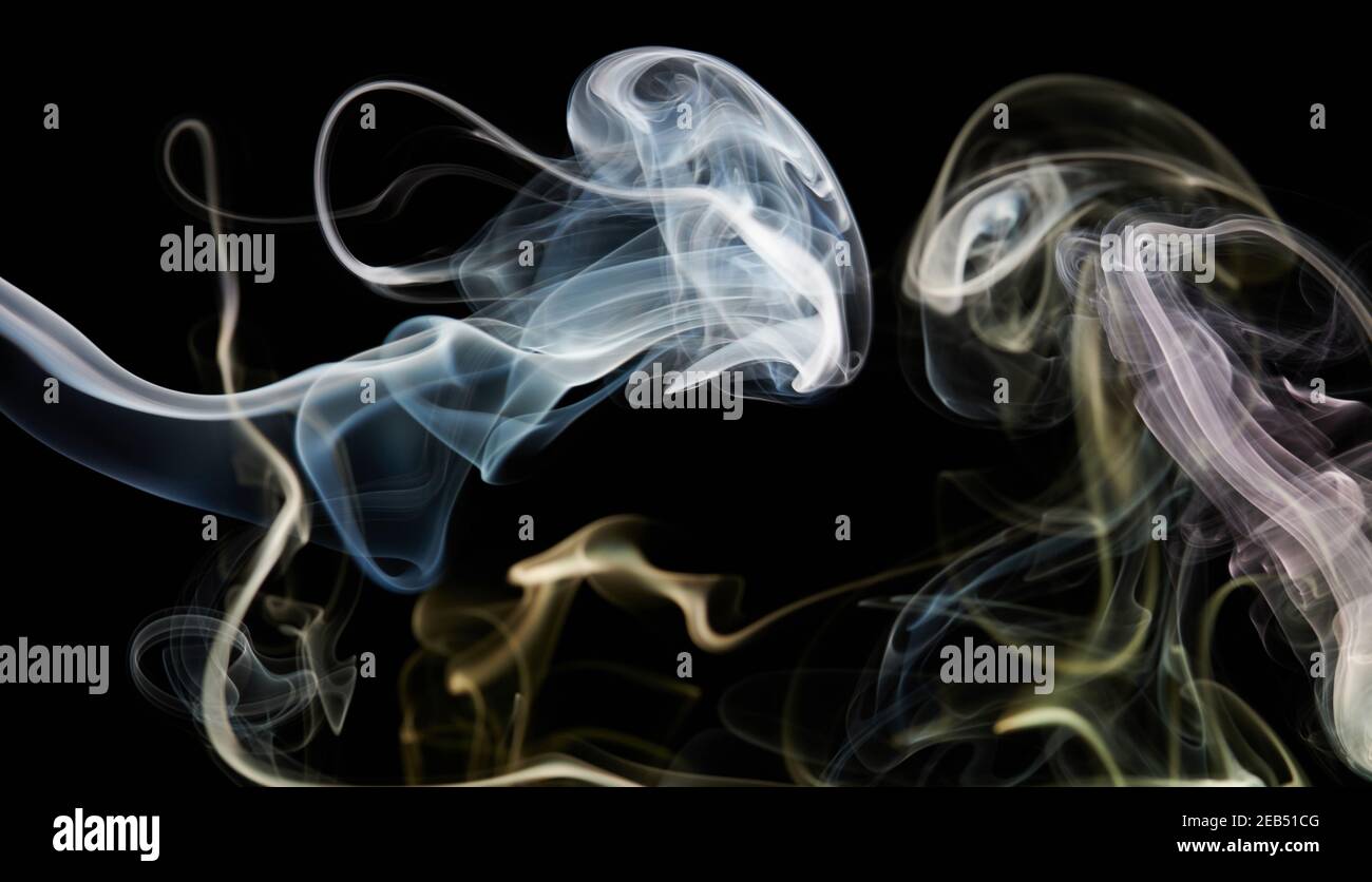 Curve di fumo bianche e gialle su sfondo nero isolato Foto Stock