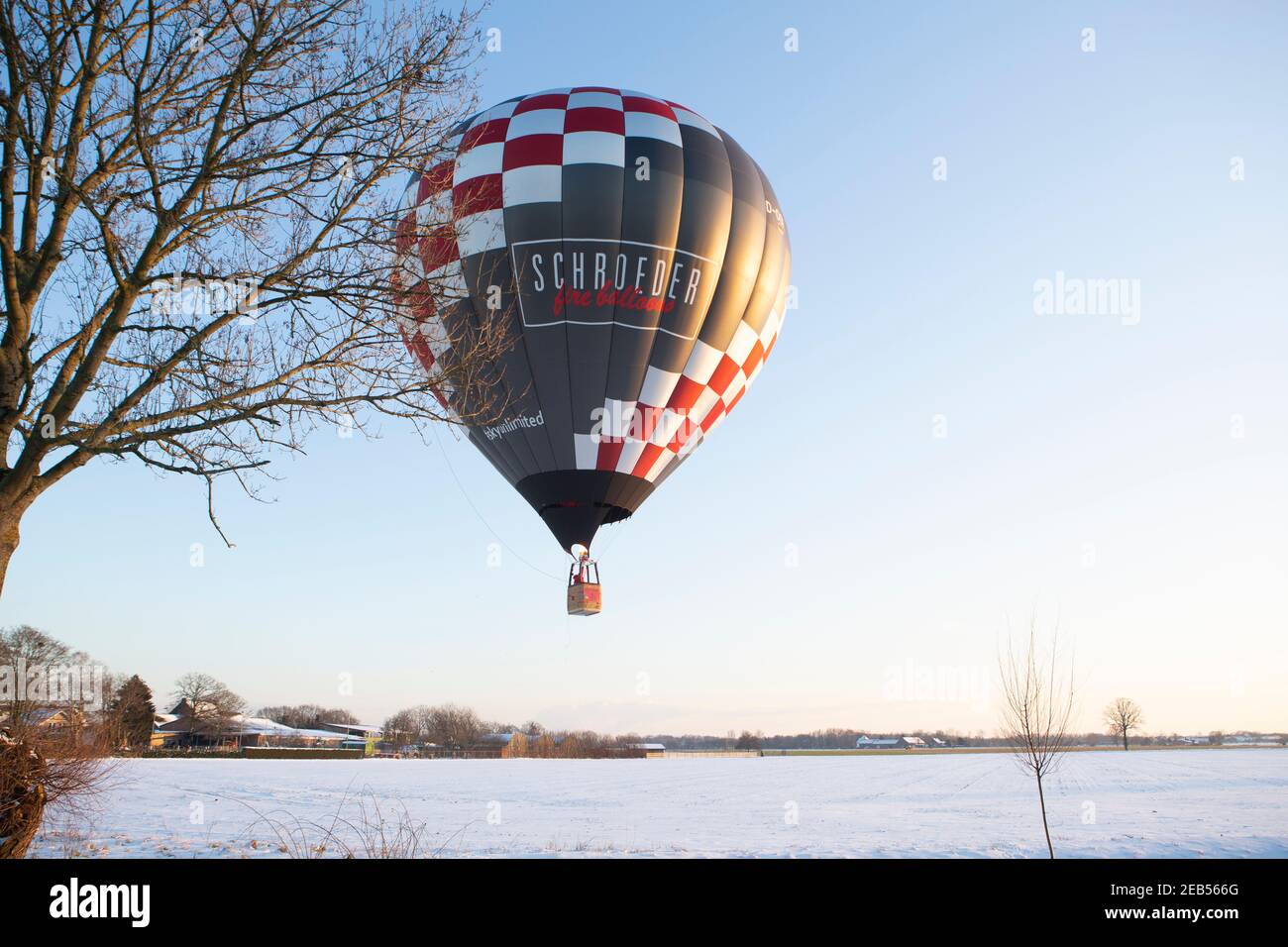 Heissluftballon über den verschneiten Wiesen bei Willich in den Nachmittagstorden. Foto Stock