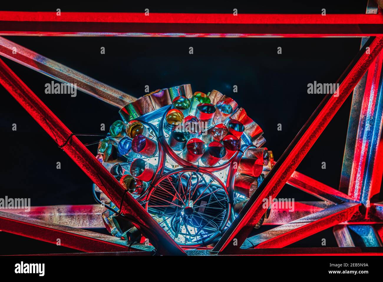 Un'orbita o una sfera fatta giace su barre di ferro di notte. Dogy capsula aliena sferica illuminata da luci rosse trasmette sentimenti extraterrestri, mistero Foto Stock