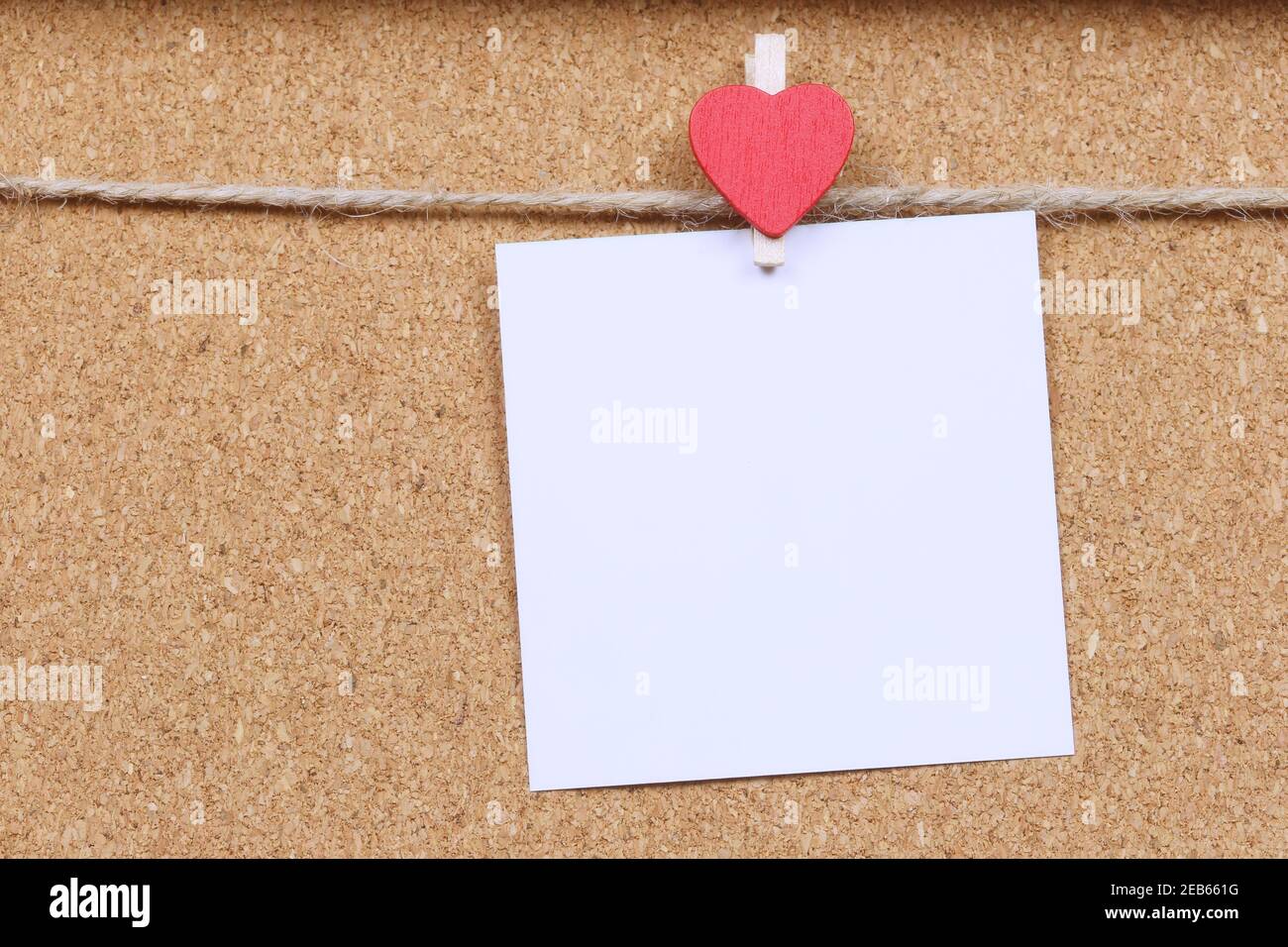 ฺBlank la nota di carta bianca appende sulla corda di canapa la parete di legno ed ha spazio di copia. Foto Stock