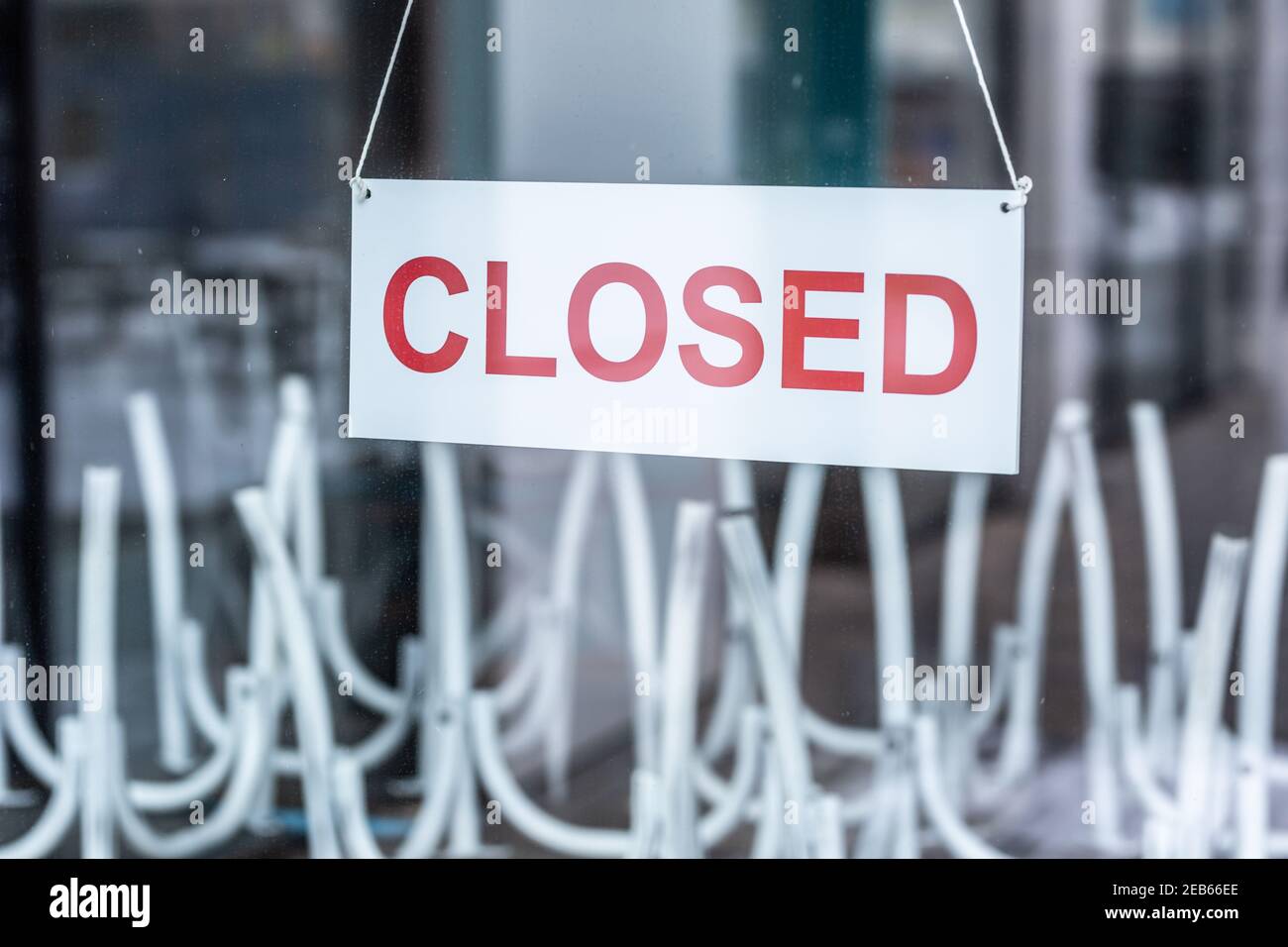 Cartello con scritto chiuso appeso alla porta di vetro di un ristorante o di un bar. Foto Stock