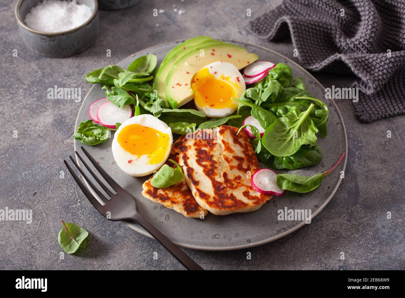Una sana cheto paleo dieta colazione: uova sode, avocado, il formaggio halloumi, foglie di insalata Foto Stock