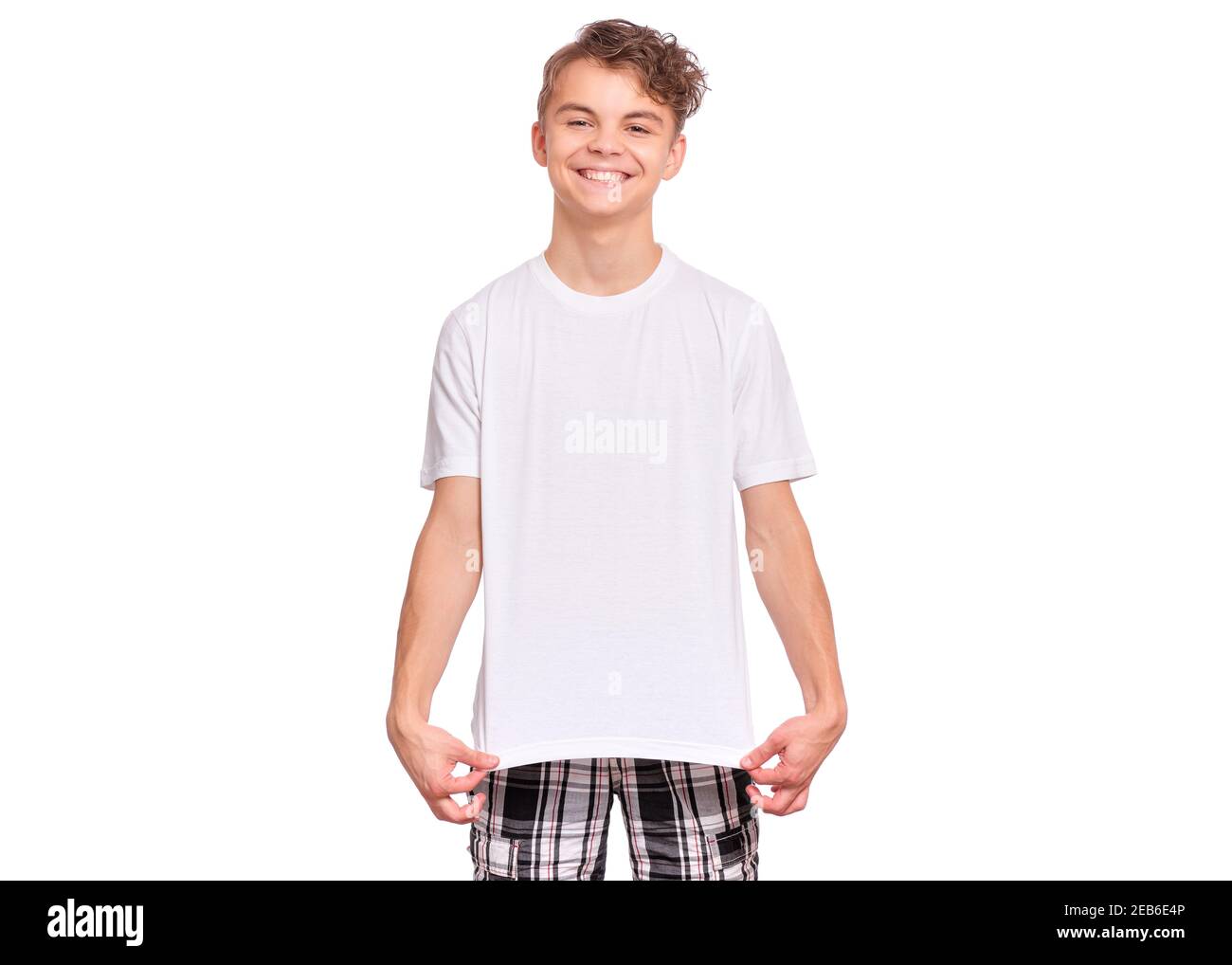 Ragazzo sorridente che punta le dita verso la t-shirt vuota mostrando spazio di copia vuoto, isolato su sfondo bianco Foto Stock