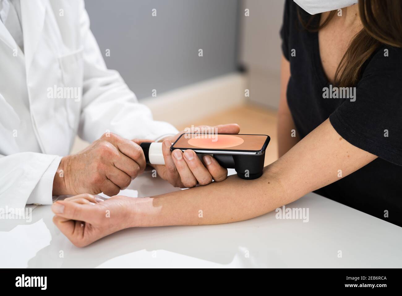 Medico che esamina la pelle pigmentata della donna del paziente Foto Stock