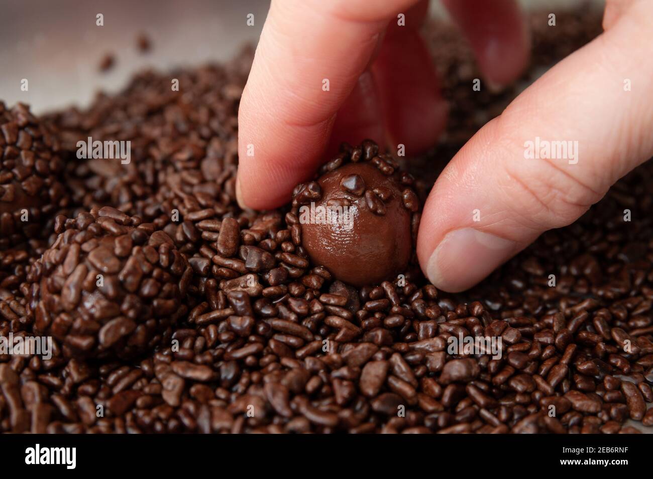 Raccogliendo a mano BRIGADEIRO su vassoio in alluminio il brigadeiro è un dolce tradizionale brasiliano. Primo piano. Vista dall'alto. Foto Stock