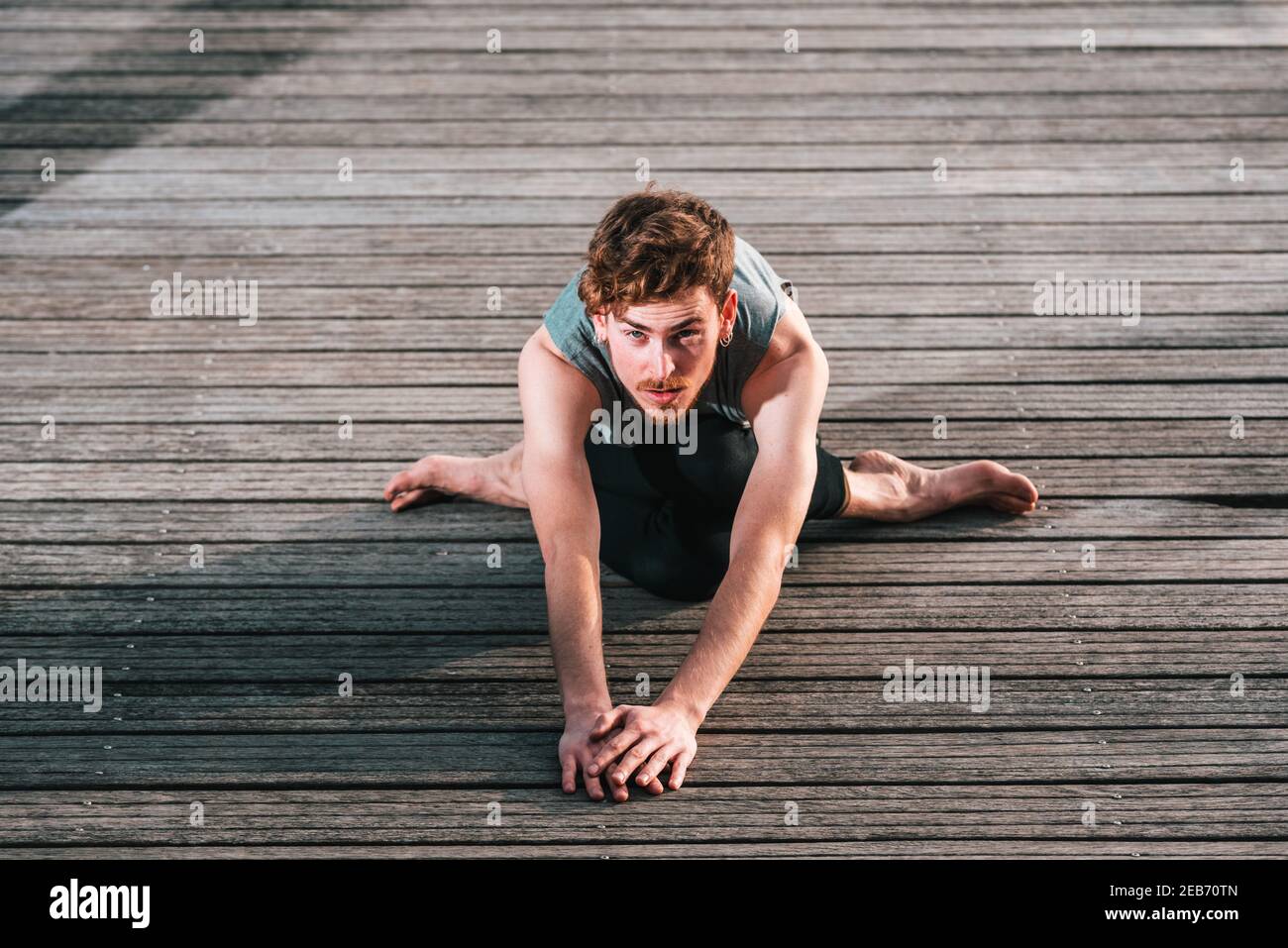Giovane atleta dai capelli rossi che si allenano per ottenere il tono muscolare e essere in buona forma per l'estate. Foto Stock