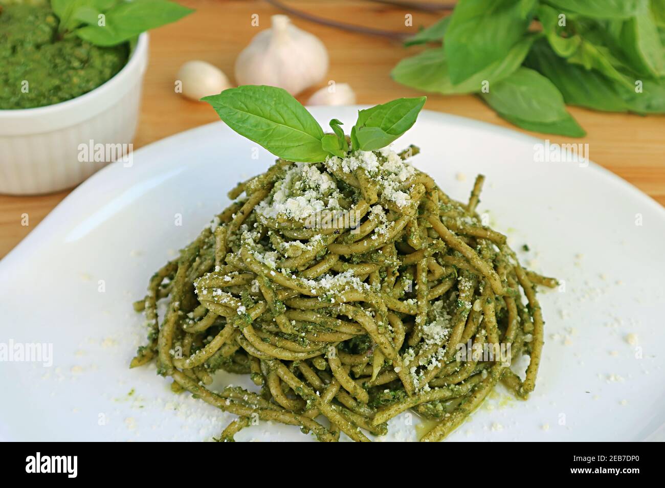 Piatto di delizioso Pesto fatto in casa salsa integrale Spaghetti con fresco Ingredienti in background Foto Stock
