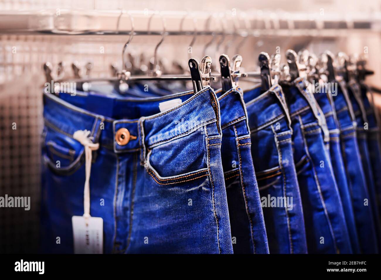 Su appendiabiti in metallo appendono jeans blu di moda classica in diverse  misure. Vendita di abbigliamento nel centro commerciale. Stile casual Foto  stock - Alamy