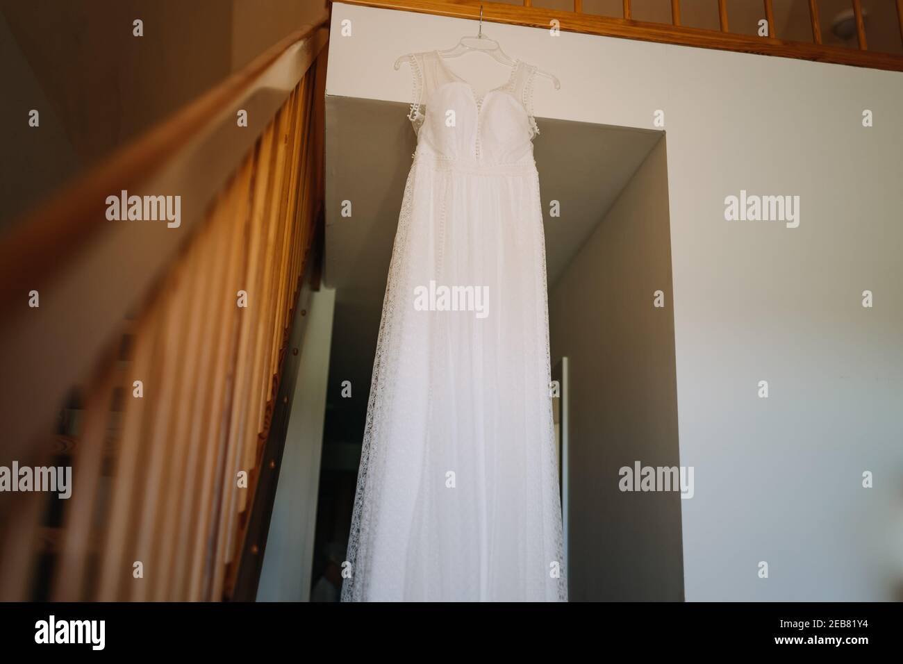 foto di un abito da sposa appeso in camera Foto Stock