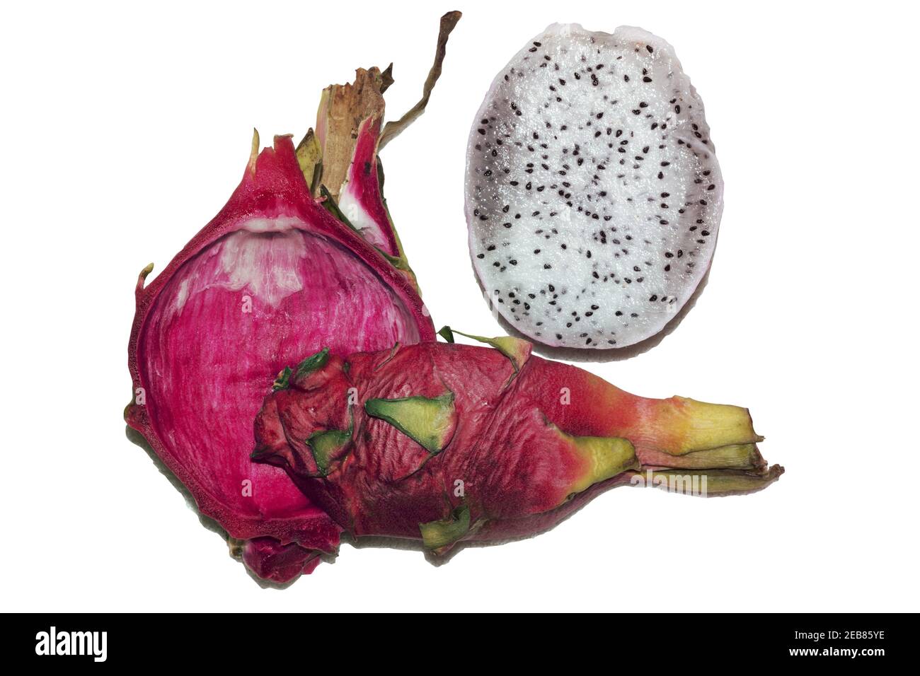 pitahaya bianca tagliata a pezzi, metà senza pelle scottata, un quarto intero di frutti rosa esotici tropicali con polpa bianca con piccoli semi neri, Foto Stock