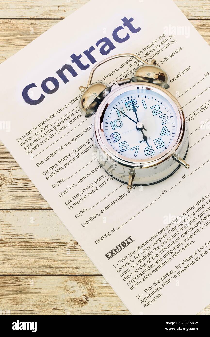 messa a fuoco selettiva del dettaglio di un orologio analogico acceso top di un contratto pronto a firmare il contratto di concetto tempo Foto Stock