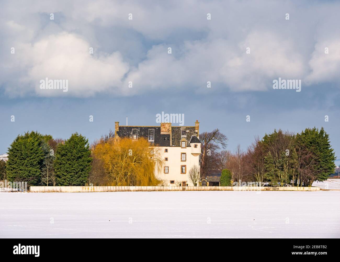 East Lothian, Scozia, Regno Unito, 12 febbraio 2021. Regno Unito Meteo: Ballencrieff House, una casa in stile baronale scozzese fortificato circondata dalla neve in inverno con un cielo tempestoso Foto Stock