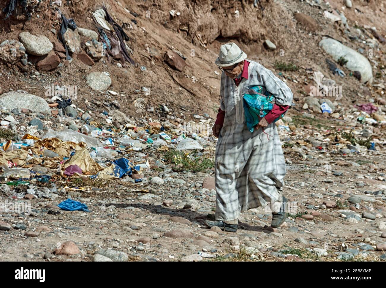 vecchio uomo che cammina in un sentiero con rifiuti pieni dentro marocco Foto Stock