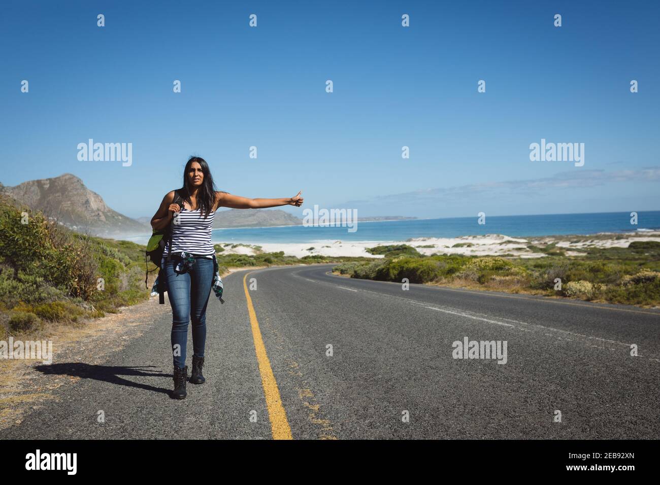 Misto razza donna a piedi per la strada e hitchhiking Foto Stock