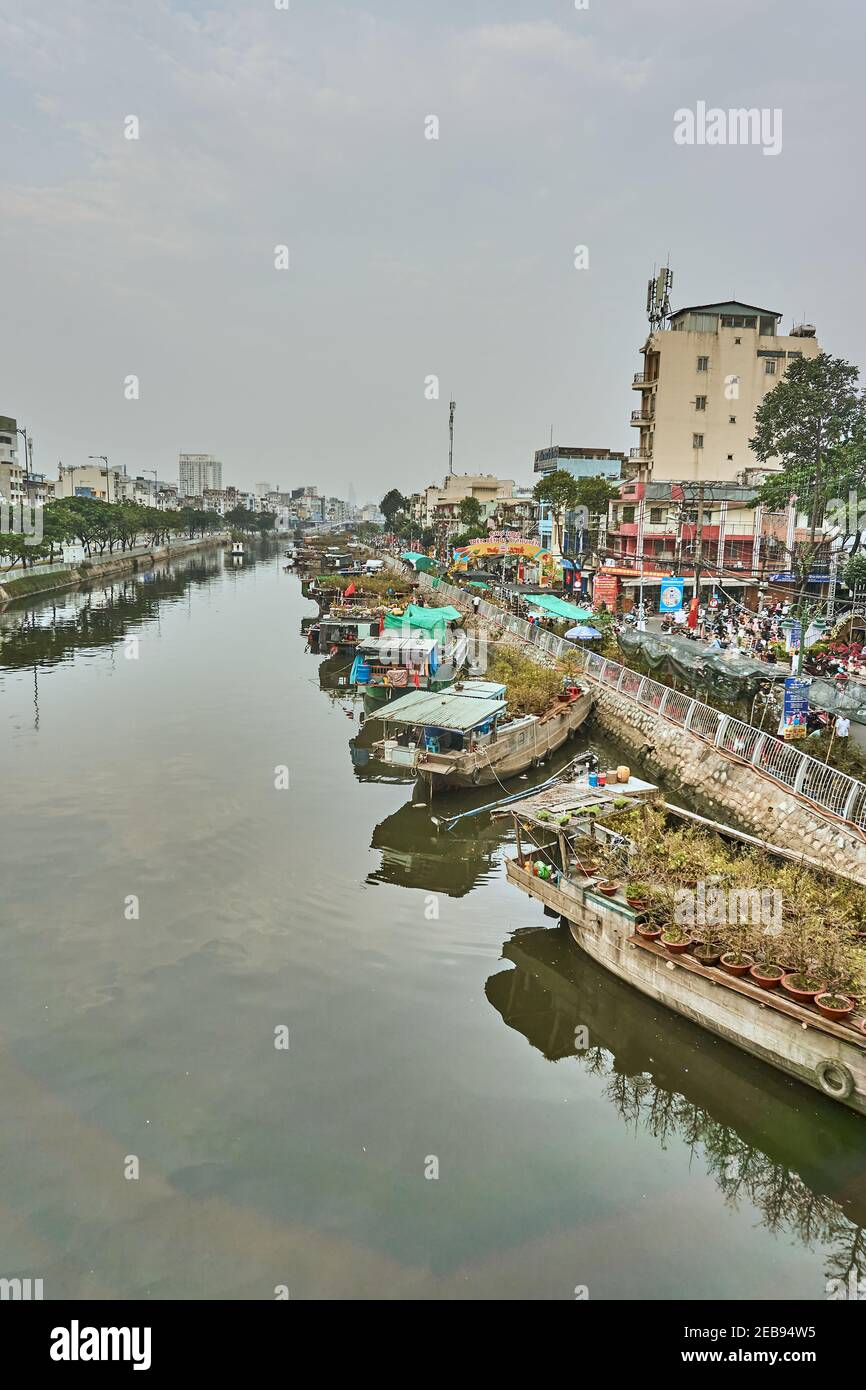 Mercato dei fiori su un fiume nella città di ho Chi Minh, Vietnam. I commercianti che mostrano i loro fiori sulle barche per i clienti da acquistare. Febbraio 2021. Foto Stock