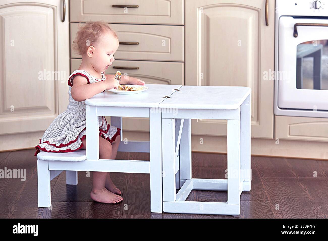 Sweet Baby mangia da sola a una piccola scala-tavolo pieghevole Sedia Foto Stock