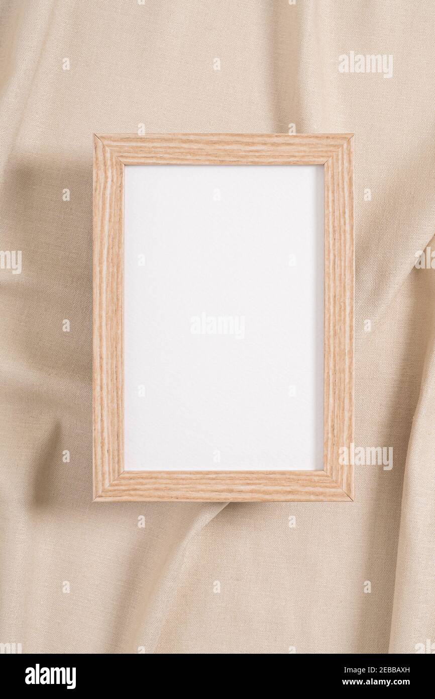 Cornice in legno con mockup bianco su tessuto beige Foto Stock
