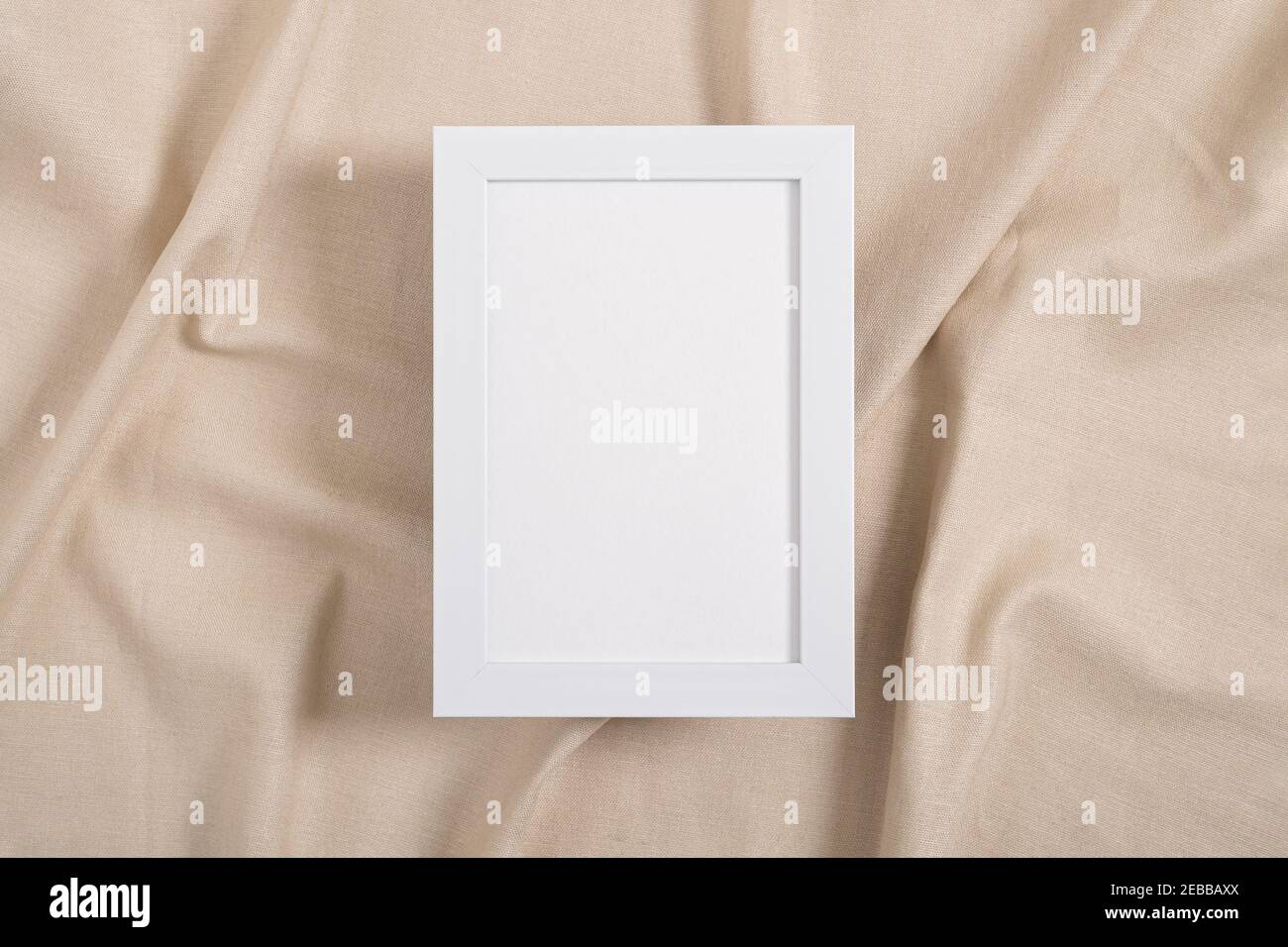 Immagine bianca mockup cornice su un tessuto beige Foto Stock