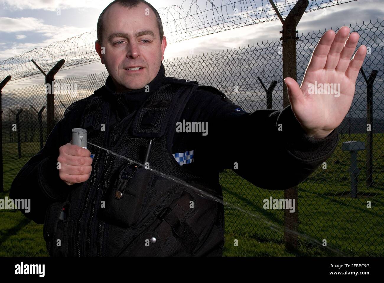 Responsabile della polizia del Regno Unito che utilizza spray inabilitante Foto Stock