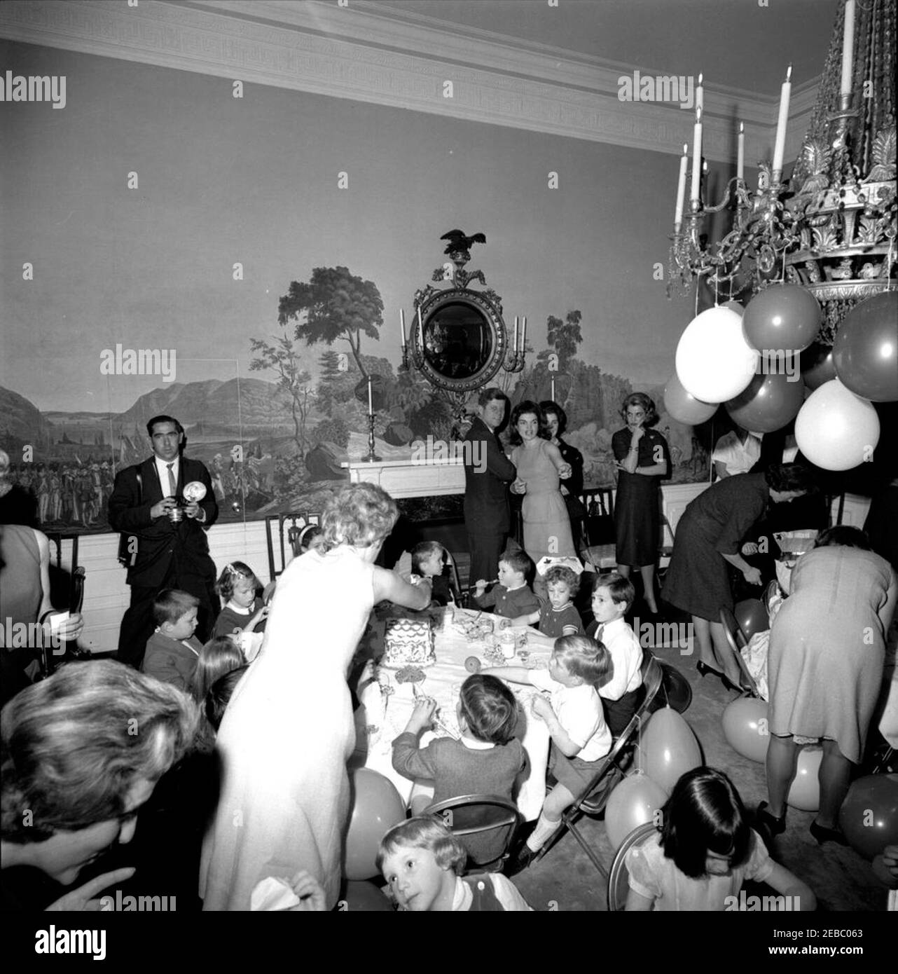 Festa di compleanno per Caroline Kennedy e John F. Kennedy, Jr. Il presidente John F. Kennedy e la First Lady Jacqueline Kennedy (entrambi al centro destra, in background) partecipano a una festa di compleanno congiunta per i loro bambini, Caroline Kennedy e John F. Kennedy, Jr.; Janet Auchincloss (parzialmente nascosto), si trova dietro la signora Kennedy. Anche nella foto: Primo segretario sociale Ladyu0027s, Letizia Baldrige; fotografo della Casa Bianca, capo Robert L. Knudsen. Presidentu2019s Dining Room (Residence), Casa Bianca, Washington, D.C. Foto Stock