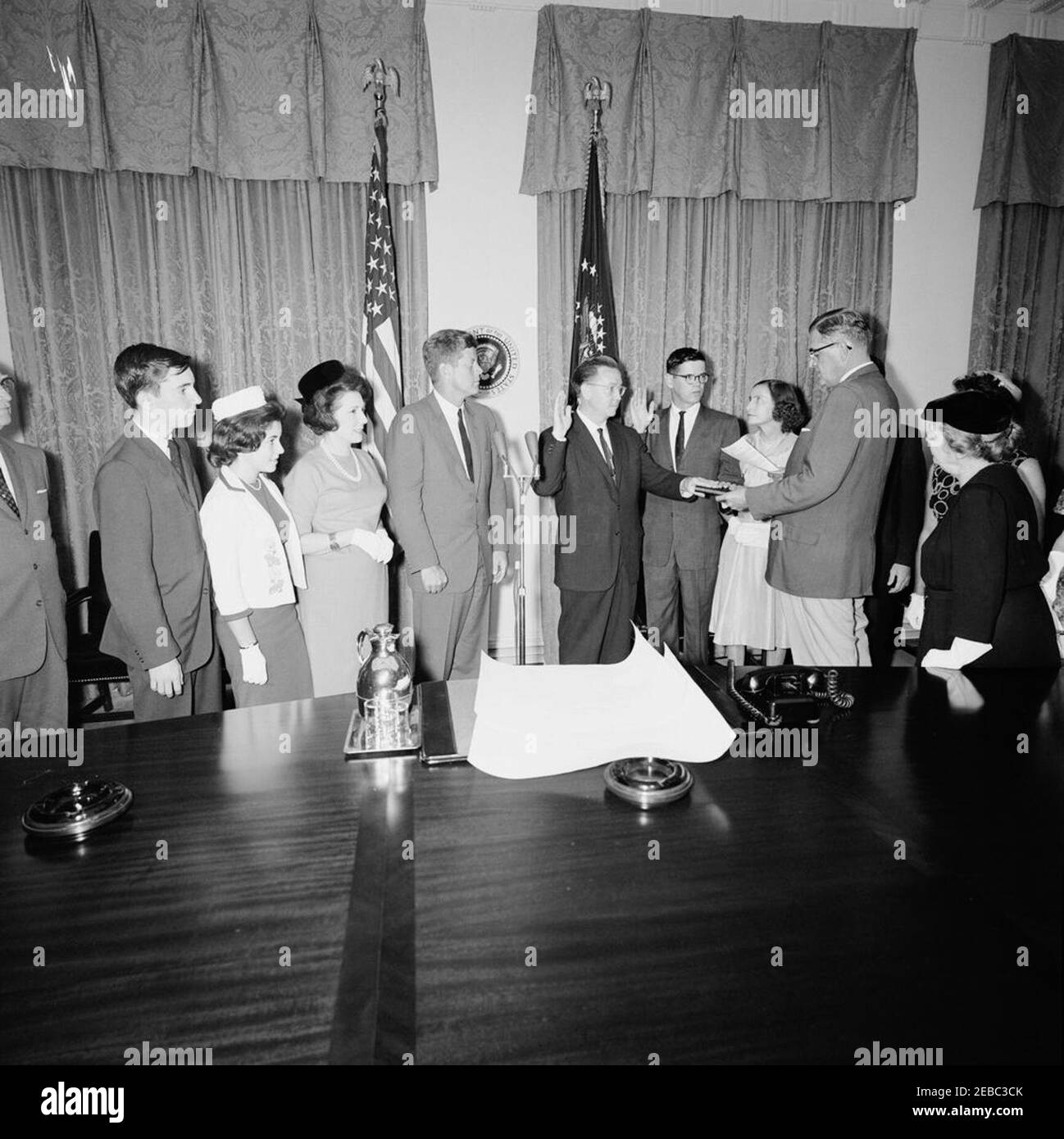 Cerimonia di giuramento, James Ramey u0026 John Palfrey, membri della Commissione per l'energia atomica (AEC), 12:30. Il presidente John F. Kennedy ed altri osservano come James T. Ramey e John G. Palfrey sono giurati dentro come membri della Commissione di energia atomica (AEC); assistente esecutivo Clerk della Casa Bianca, Herbert L. Miller, amministra il giuramento. Da sinistra a destra: Presidente del Comitato congiunto per l'energia atomica, Rappresentante Chet Holifield della California (soprattutto fuori quadro); James N. Ramey; Drucilla Ramey; Dr. Estelle R. Ramey; Presidente Kennedy; nuovi commissari AEC, James T. Ramey e J. Foto Stock