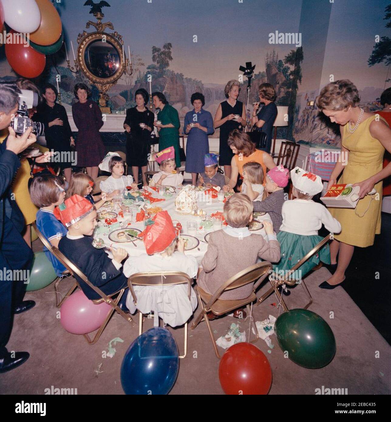 Festa di compleanno per Caroline Kennedy e John F. Kennedy, Jr. La First Lady Jacqueline Kennedy siede al tavolo con sua figlia, Caroline Kennedy, durante una festa di compleanno congiunta per Caroline e John F. Kennedy, Jr. Avery Hatcher, figlio del Segretario della Stampa associato, Andrew T. Hatcher, siede a sinistra di Caroline; Maria Shriver siede a sinistra in primo piano. Anche nella foto: White House photographer, Captain Cecil Stoughton; Eunice Kennedy Shriver; Janet Auchincloss; First Ladyu0027s Social Secretary, Letitia Baldrige. Presidentu2019s Dining Room (Residence), Casa Bianca, Washington, D.C. Foto Stock