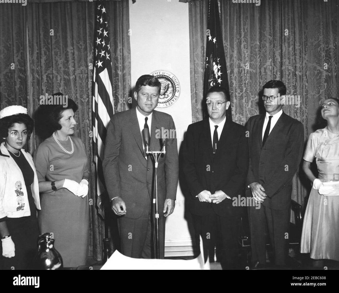 Cerimonia di giuramento, James Ramey u0026 John Palfrey, membri della Commissione per l'energia atomica (AEC), 12:30. Il presidente John F. Kennedy ha espresso le sue osservazioni durante la cerimonia di giuramento per i membri della Commissione per l'energia atomica (AEC), James T. Ramey e John G. Palfrey. Da sinistra a destra: Drucilla Ramey; Dr. Estelle R. Ramey; Presidente Kennedy (ai microfoni); nuovi commissari AEC, James T. Ramey e John G. Palfrey; Clochette Roosevelt Palfrey. Sala armadio, Casa Bianca, Washington, D.C. Foto Stock