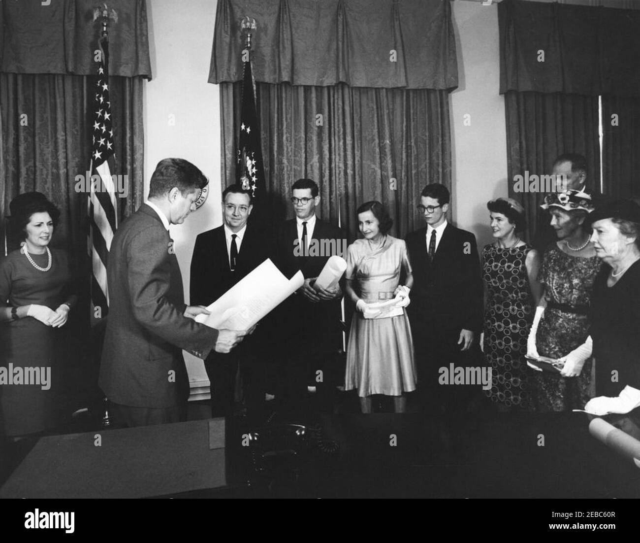 Cerimonia di giuramento, James Ramey u0026 John Palfrey, membri della Commissione per l'energia atomica (AEC), 12:30. Il presidente John F. Kennedy presenta i certificati di nomina ai membri della Commissione per l'energia atomica (AEC), James T. Ramey e John G. Palfrey, in seguito al loro giuramento. Da sinistra a destra: Dr. Estelle R. Ramey; Presidente Kennedy; nuovi commissari AEC, James T. Ramey e John G. Palfrey; Clochette Roosevelt Palfrey; John G. u0022Seanu0022 Palfrey, Jr.; Sarah Palfrey Danzig; Presidente dell'AEC, Dr. Glenn T. Seaborg (in dietro); metil Oroosevelt Palfrey; Belle Roosevelt. Cabina Foto Stock