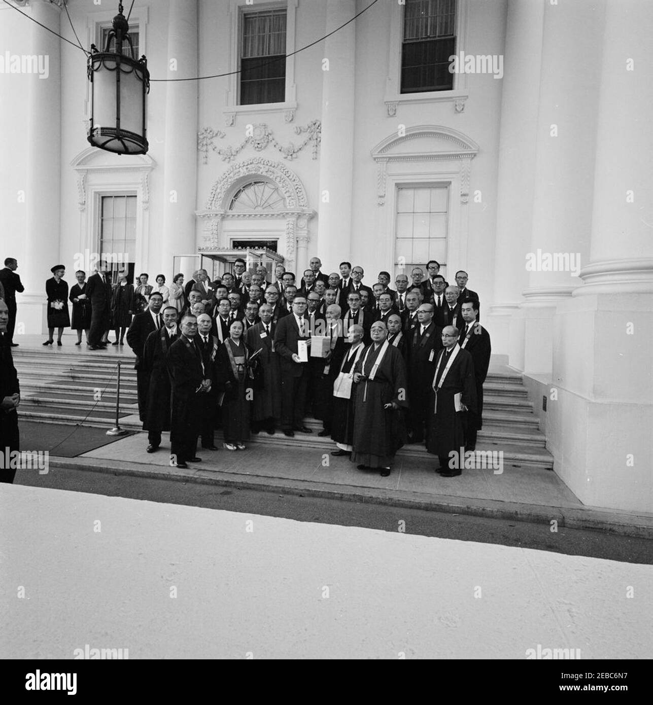 Presentazione di un regalo per il presidente da parte di delegati delle sette buddiste in Giappone in occasione del 70° anniversario del Buddismo in America (McNally). L'assistente presidenziale, John J. McNally, accetta i regali per il presidente John F. Kennedy dai delegati dalle sette buddiste in Giappone per celebrare il 70° anniversario del buddismo in America. North Portico, Casa Bianca, Washington, D.C. [fotografia di Dan Lewis] Foto Stock