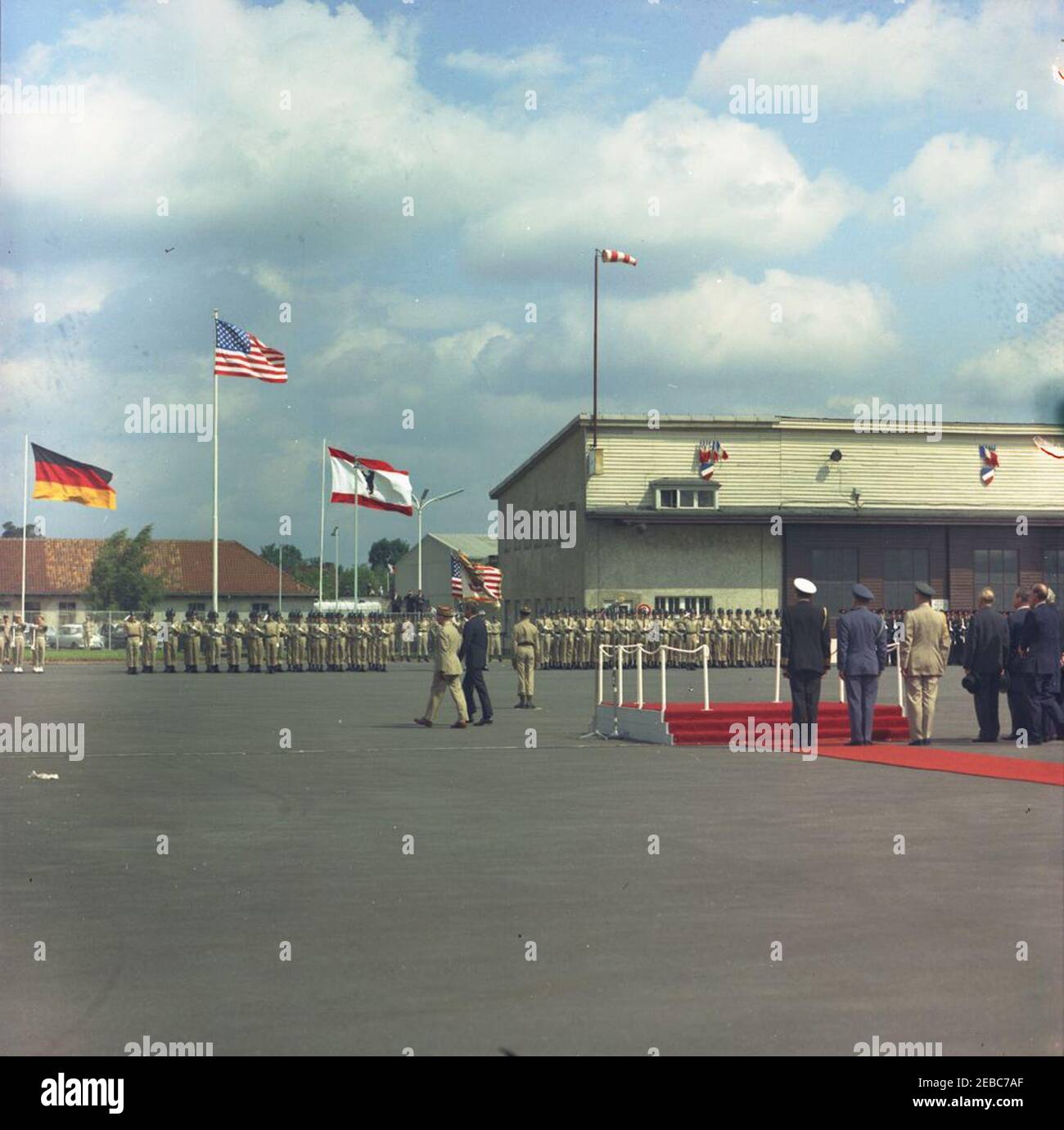 Viaggio in Europa: Germania, Berlino Ovest: Il Presidente Kennedy arriva all'aeroporto di Tegel. Il presidente John F. Kennedy (centro a sinistra, di nuovo alla macchina fotografica) ispeziona le truppe della guardia d'onore durante la cerimonia di arrivo all'aeroporto di Tegel a Berlino Ovest, Germania Ovest (Repubblica Federale); il comandante francese a Berlino, il generale maggiore Edouard Toulouse cammina a sinistra del presidente Kennedy. Tra le persone a destra figurano: Cancelliere della Germania occidentale, Konrad Adenauer; Sindaco di Berlino Ovest, Willy Brandt; Naval Aide al presidente, Capitano Tazewell T. Shepard, Jr.; Air Force Aide al presidente, Brigadier General Godfrey T. McHugh; Foto Stock